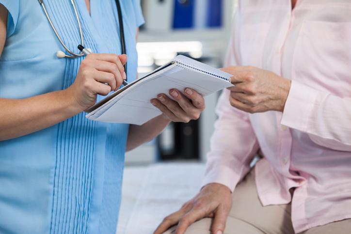 GP taking notes during patient assessment